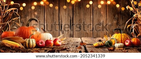 Pumpkins Apples And Corn On Rustic Harvest Table With Bokeh Lights - Harvest And Thanksgiving Background