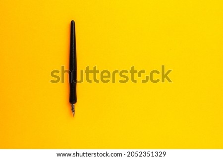 Pen on a yellow background with a copy space for text or inscriptions.