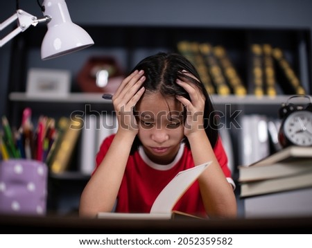 girl school student feeling headache or fatigue doing homework at home. Exhausted depressed sick teenager studying alone worried about difficult education problems concept. Royalty-Free Stock Photo #2052359582