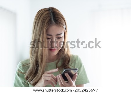Cropped image of charming asian woman using mobile phone