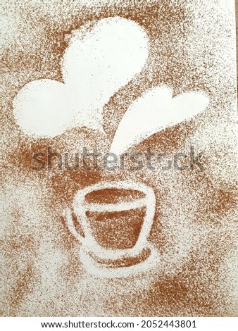 Brown background from ground coffee in the form of a silhouette of a cup and hearts