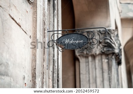 Vintage sign "Welcome" on the wall of a stone house (1059)