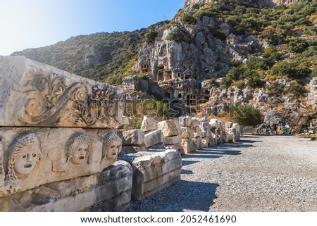 Historical Stone faces bas relief and ancient theater at Myra ancient city. Rock-cut tombs Ruins in Lycia region, Demre, Antalya, Turkey.   Royalty-Free Stock Photo #2052461690