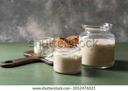 Jars with fresh sourdough on table