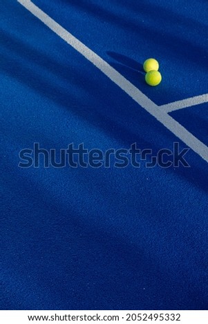 Two balls next to the lines of a paddle tennis court Royalty-Free Stock Photo #2052495332