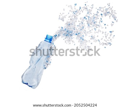 Top view of blue plastic bottle with PET bottle  transparent flakes around in white background. Plastic pollution recycle and World Environment Day concept. Royalty-Free Stock Photo #2052504224