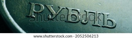Translation: ruble. Green tinted banner with the name of the Russian currency close-up. Fragment of a 1 ruble coin. Economy, finance and money of Russia. Textured scratched dirty coin. Macro