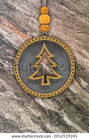 Round Christmas tree decoration with golden glitter and Christmas tree on marble background. 