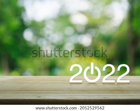 2022 start up business flat icon on wooden table over blur green tree in park, Happy new year 2022 cover concept