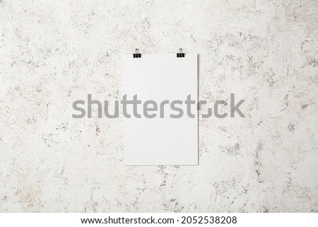 Blank poster hanging on light wall