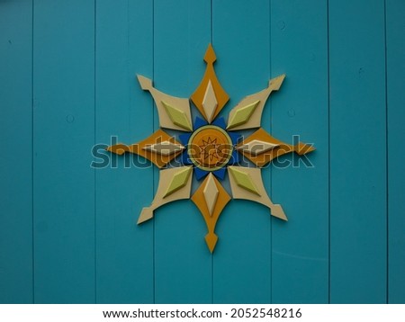 Multicolored symmetrical wood figure on blue background 