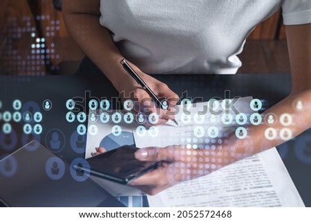 Employee signing the contract to boost her career and gain new opportunities in personal growth. Women in business concept. Checking the detail of the deal at smartphone. Social media hologram icons