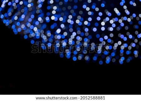 Christmas Defocused Light Garland. Blue bokeh lights on black background. Beautiful Holiday border of Bokeh light. Mockup for Design flyer to New Year, Christmas Holiday, anniversary, birthday