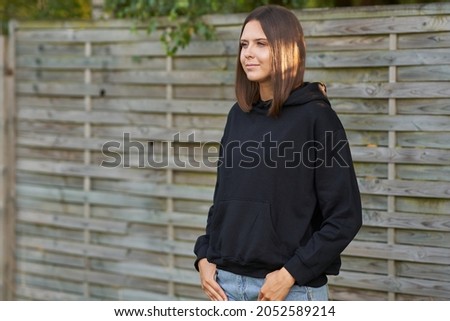 Young woman in black hoodie.