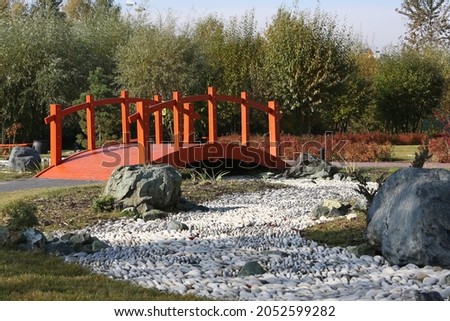Little Japan in Kurkino district, Moscow city, Russia. Japanese garden. Japanese autumn park in Moscow with stones and plants. Architecture in asian, japanese style. Red bridge in Japanese garden