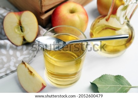 Natural apple vinegar and fresh fruits on white wooden table Royalty-Free Stock Photo #2052600479