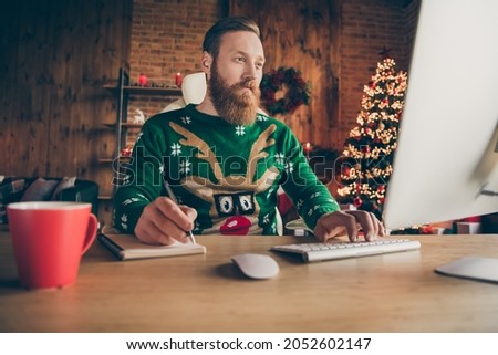 Photo of serious young focused man sit table look computer remote job write note indoors inside house home