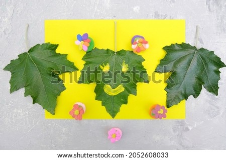 Child made flowers from plasticine and card from paper and natural leaves. Protection of environment,  Ecology concept. Concept of art learning and education 