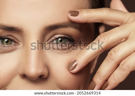 Portrait of a beautiful middle aged woman with clean wrinkled skin Royalty-Free Stock Photo #2052669314