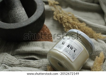 Soy candle in a jar with a mulberry scent in a beige-gray bath. Translation of the inscription from the photo: "Handmade soybean candle with the scent of mulberry".