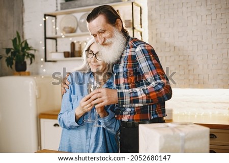 Senior couple with gifts in a kitchen