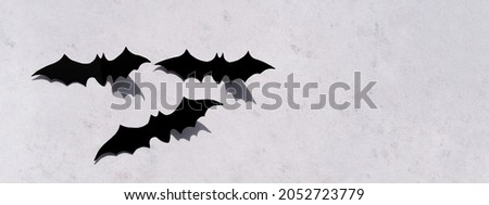 Trendy minimalistic concrete background for the Halloween holiday. Boo word. Black bat.
