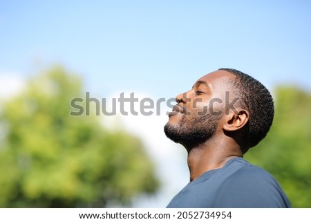 Profile of a man with black skin breathing fresh air in nature a sunny day Royalty-Free Stock Photo #2052734954