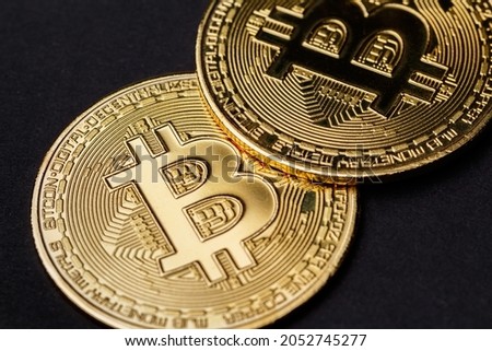 The concept of the Bitcoin cryptocurrency financial market, trading. The bitcoin cryptocurrency is the coin of the future. The Bitcoin logo on a dark background. Two shiny gold Bitcoin - macro
