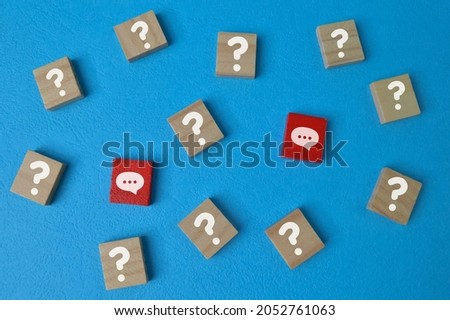 Wooden cube blocks with question mark and chat symbols. Qa concept