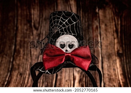 Skull mask with cobwebs and a red butterfly on a dark wooden background for halloween.