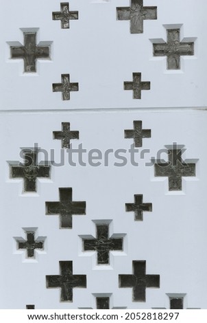 Crosses of glass in a white wall.
