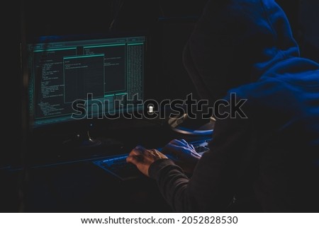 Cyber criminal hacking system at monitors, hacker hands at work. Internet crime concept. Hacker steals password attack victim computer working on code in dark. Hacking and malware concept. Cybercrime Royalty-Free Stock Photo #2052828530