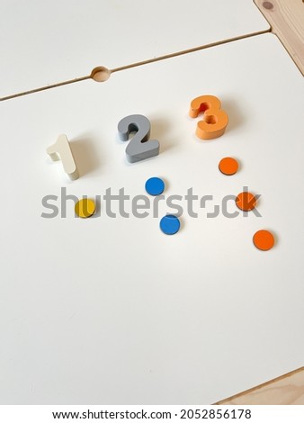Bright wooden numbers on a white table. The concept of studying mathematics, counting and numbers. Preschool education. Counting material. Numbers: one, two, three.