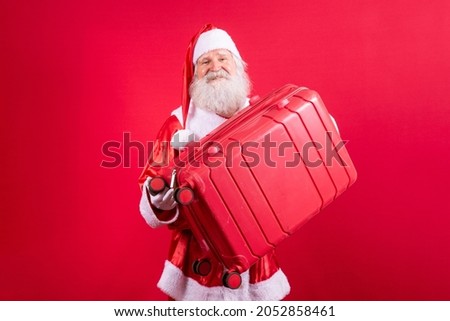 Santa Claus with his suitcase. New Year's travel concept. Santa Claus at the airport.

