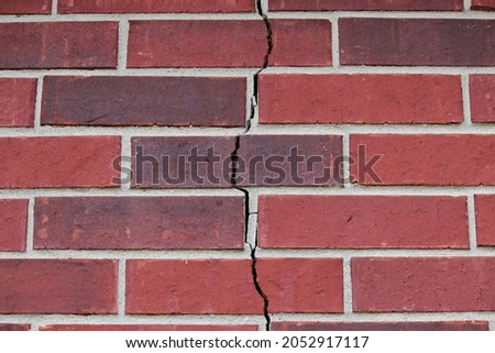 Crack in the brick wall due to a foundation problem, settling of the house Royalty-Free Stock Photo #2052917117