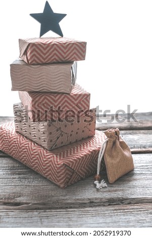 High pyramid of gift Christmas boxes with a wooden star and sustainable pouch bag. Ecological Christmas holiday concept, eco decor. High quality photo