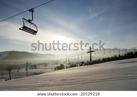 Ski lifts and ski run. There is skyline of Tatra Mountains on background.