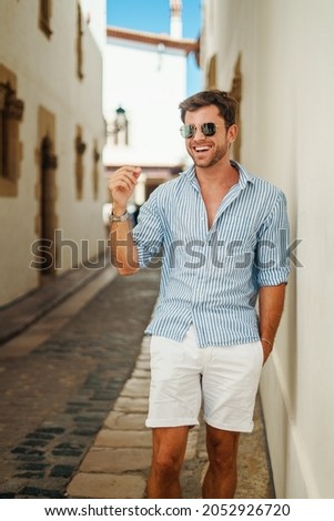Cheerful man walking on narrow street Royalty-Free Stock Photo #2052926720