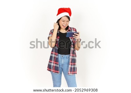 Playing Game on Smartphone of Beautiful Asian Woman Wearing Red Plaid Shirt and Santa Hat Isolated On White Background