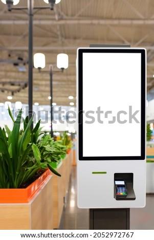 Self service electronic counter with blank mockups on white screen and payment terminal in fast food restaurant, shopping mall Royalty-Free Stock Photo #2052972767