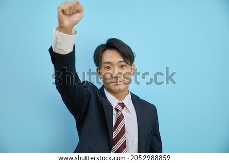 A man in a suit who raises his fist and cheers