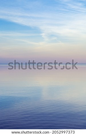 Beautiful sunset on sea, pastel colors and reflections on water, calm nature landscape with colorful clouds and sea. Environment natural gradient. Abstract background. 