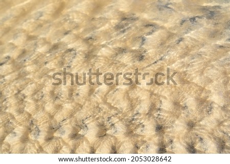 Close up.Sand golden texture and pattern for background.Water flowing into the sea.Water in the river flows down.