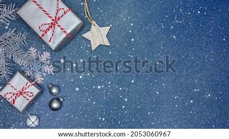 xmas greeting card with silver gift boxes, star, decorations on festive blue background. new year. noel.