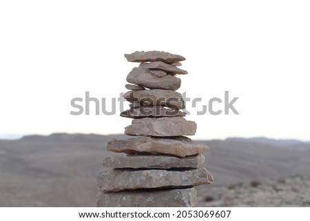 Cairn at sunrise, stones balances, pyramid of stones at sunset, concept of life balance, harmony and meditation. A pile of stones in desert mountains, crater Ramon, Israel