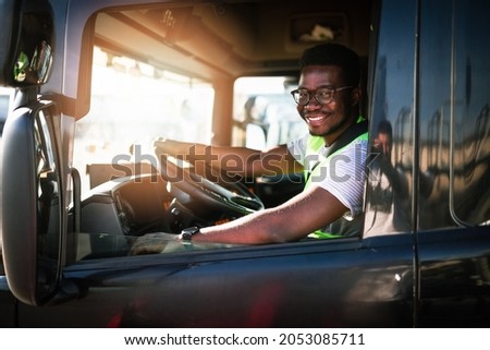 Young handsome African American man working in towing service and driving his truck. Royalty-Free Stock Photo #2053085711