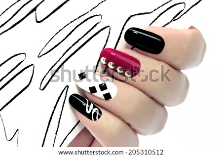 Colorful graphic manicure on an oval shaped nails are covered with black,white,red lacquer. Royalty-Free Stock Photo #205310512