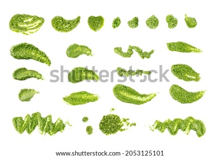 Pesto spread or blob isolated on white background. Green italian homemade spilled sauce made of ground basil, garlic, pine seeds, olives and pecorino sardo cheese top view Royalty-Free Stock Photo #2053125101