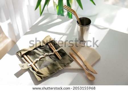 Eco cutlery and cup on table in kitchen