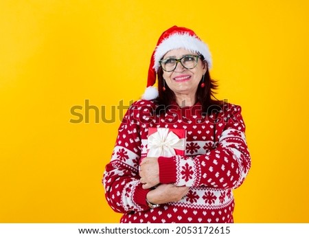 happy smiling mature woman holds gift box with red bow christmas present yellow background
